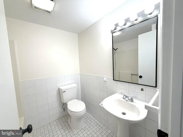 a bathroom with a toilet sink a mirror and shower