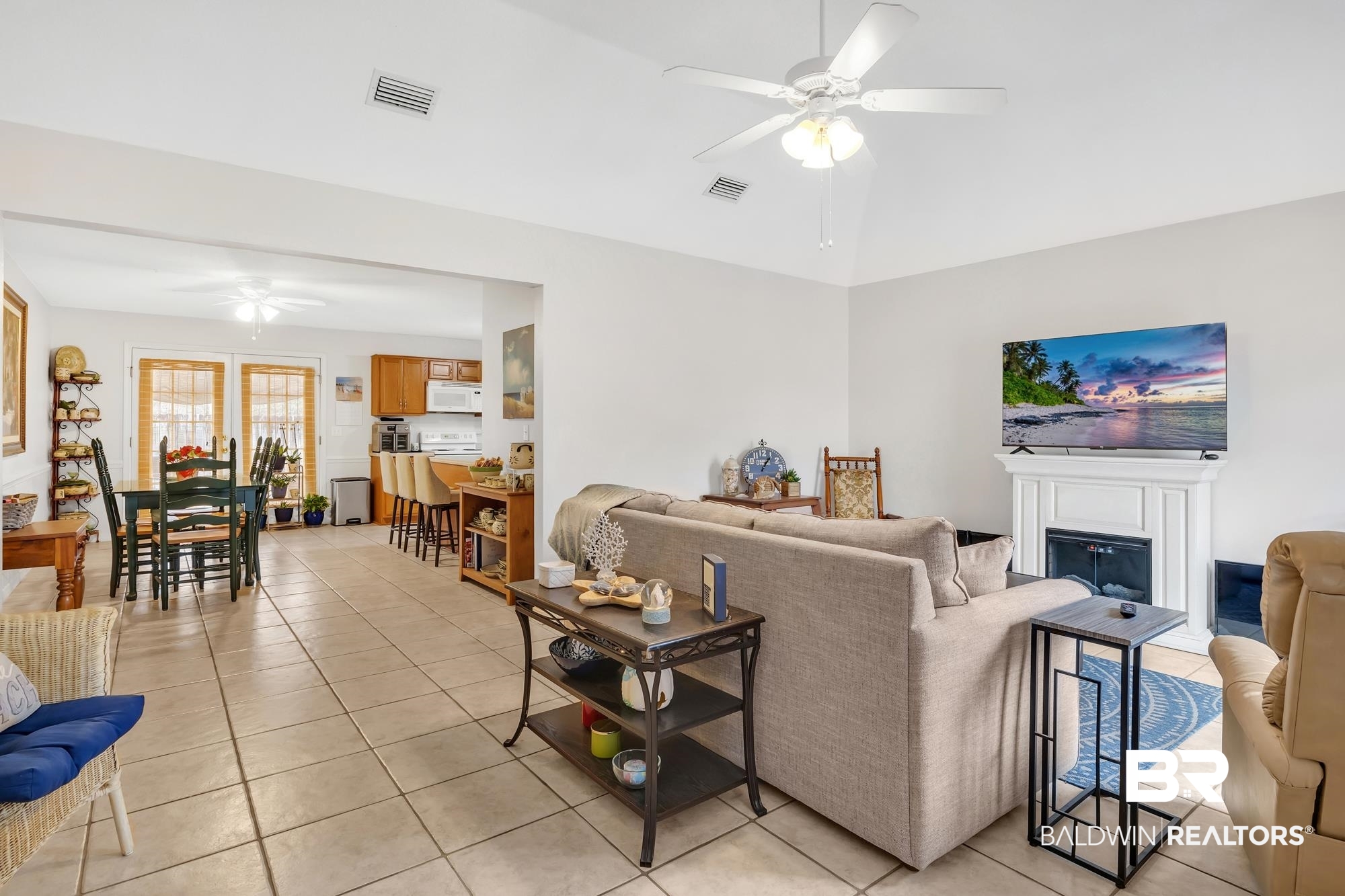 105 Cluster Oaks Court Foley, AL 36535 - Photo 10 of 26 Living room featuring ceiling fan, light tile patterned floors, a fireplace, and vaulted ceiling