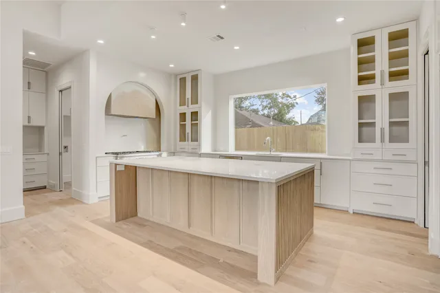 a view of an empty room with glass door and chandelier