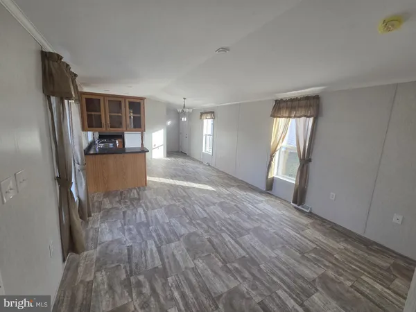 a view of a kitchen with wooden floor and a refrigerator