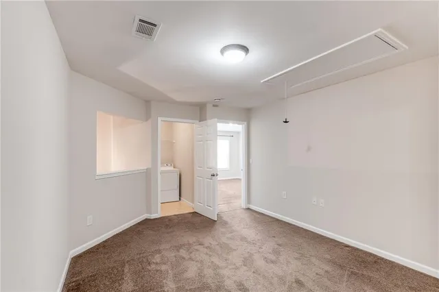 an empty room with chandelier fan and windows