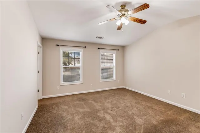 an empty room with closet and a chandelier fan