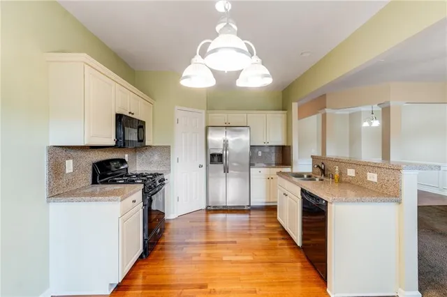 a bathroom with a sink a faucet a light fixture and a glass door