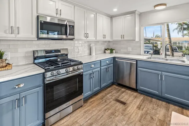 a kitchen with stainless steel appliances granite countertop a stove a sink and a microwave