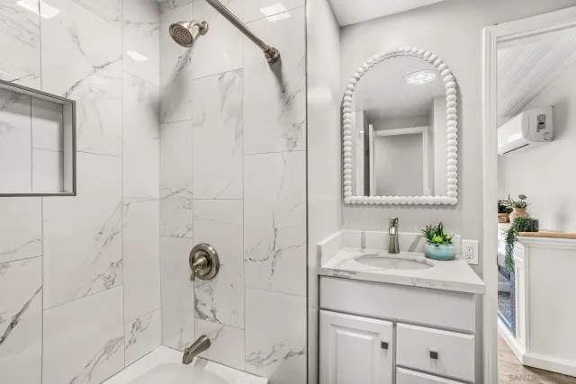 a bathroom with a shower sink and mirror