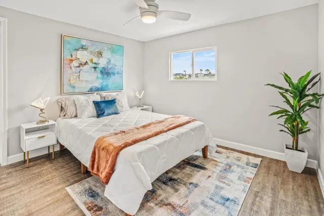 a bedroom with a large bed and a potted plant