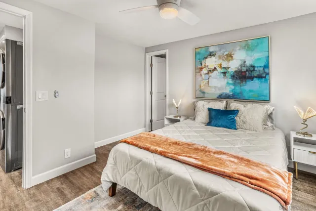 a bedroom with a bed and a painting on the wall