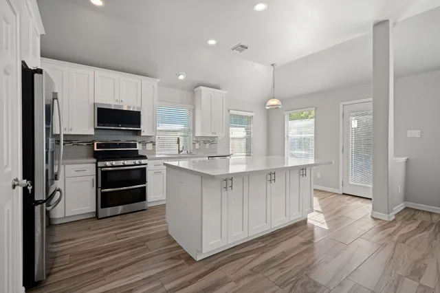 a kitchen with stainless steel appliances a stove top oven and refrigerator