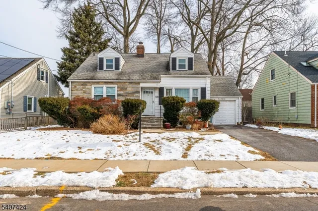 a front view of a house with a yard covered in snow