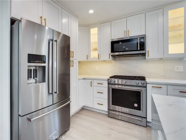 a kitchen with cabinets and stainless steel appliances