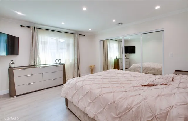 a bedroom with a bed and a flat screen tv in it