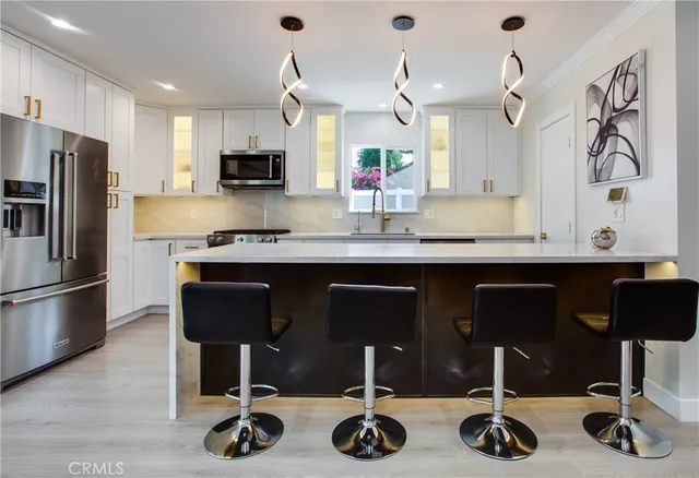 a kitchen with granite countertop a sink stainless steel appliances and cabinets