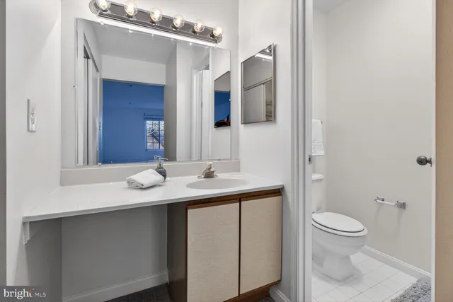 a bathroom with a toilet a sink and mirror