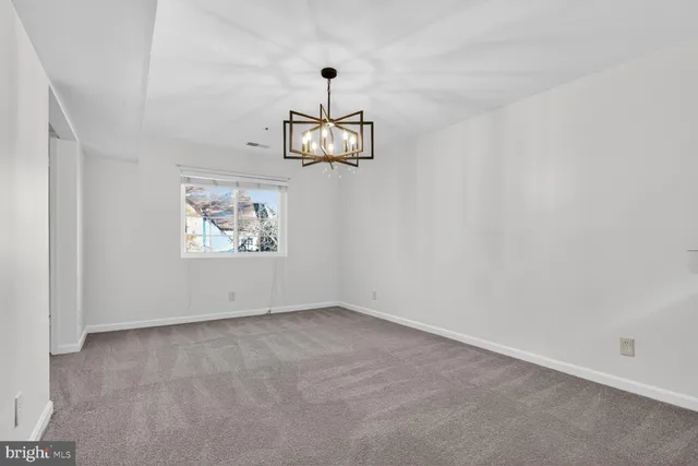 an empty room with a wooden floor and windows