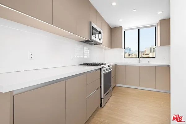 a kitchen with a sink stove and cabinets