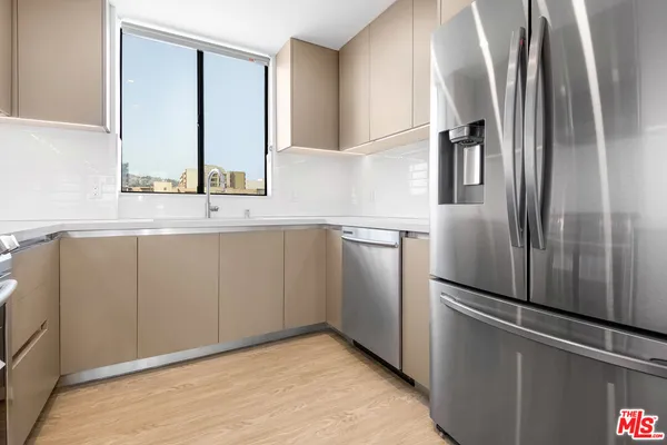 a kitchen with stainless steel appliances a refrigerator and a sink