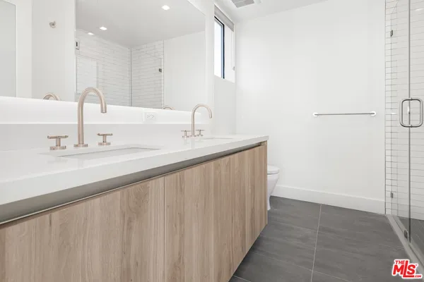 a bathroom with a double vanity sink and a mirror