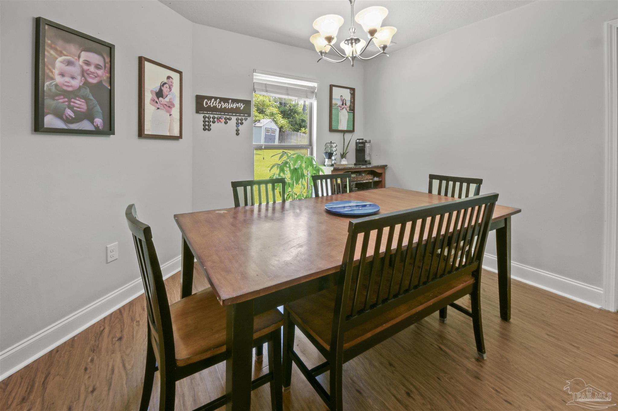 300 Cassady Lane Crestview, FL 32539 - Photo 11 of 25 a view of a dining room with furniture a chandelier and wooden floor