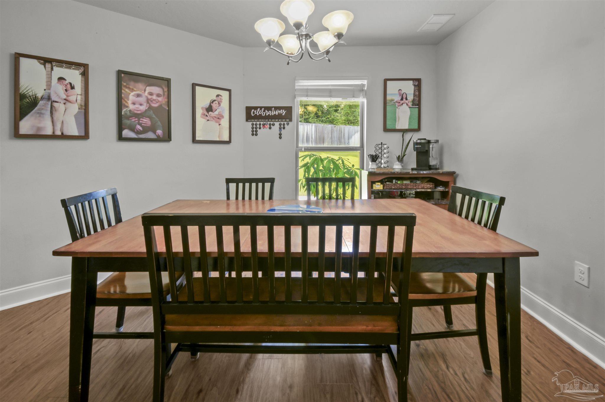300 Cassady Lane Crestview, FL 32539 - Photo 12 of 25 a view of a dining room with furniture a chandelier and wooden floor