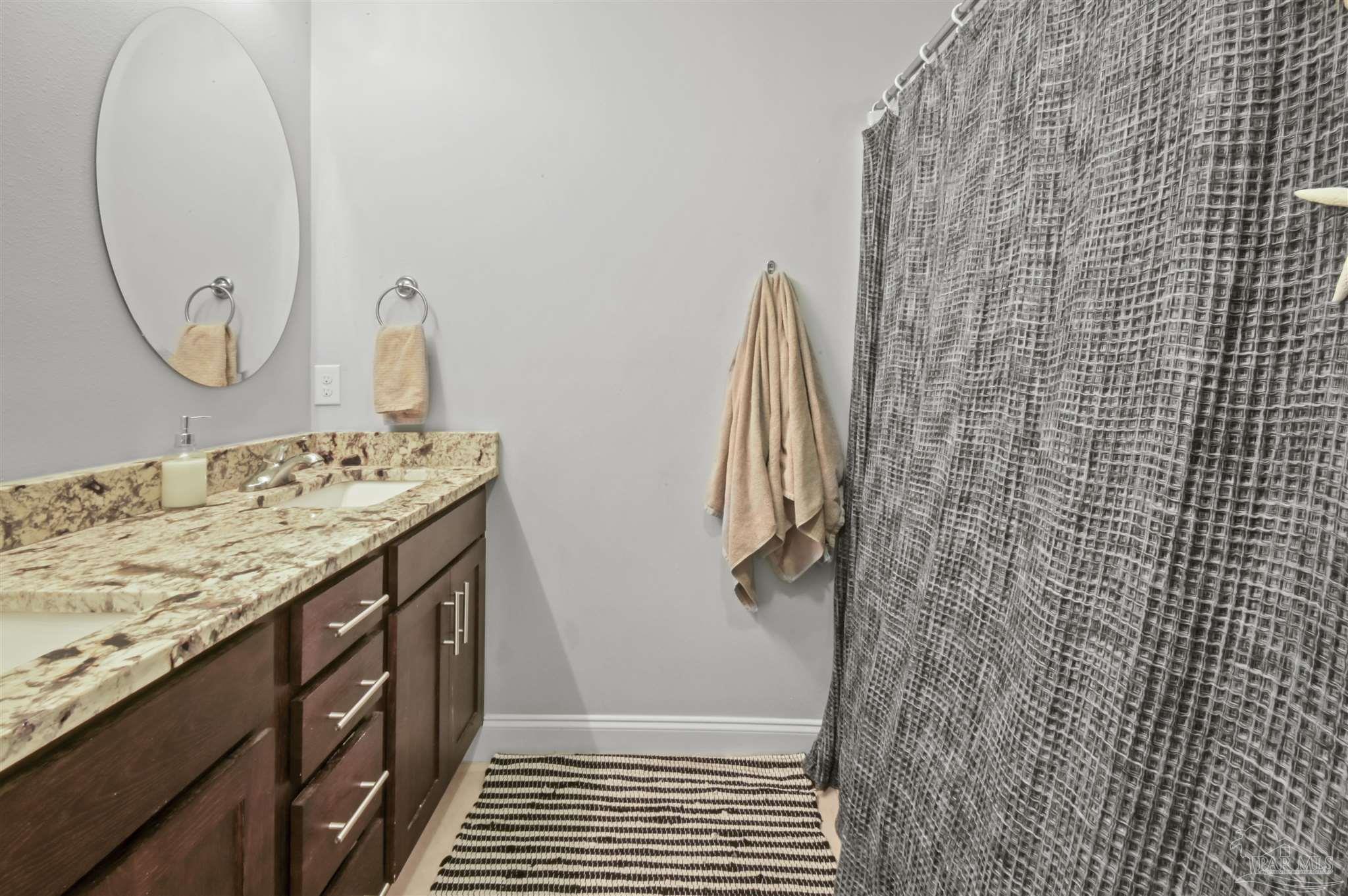 300 Cassady Lane Crestview, FL 32539 - Photo 15 of 25 a bathroom with a granite countertop sink a shower and a mirror