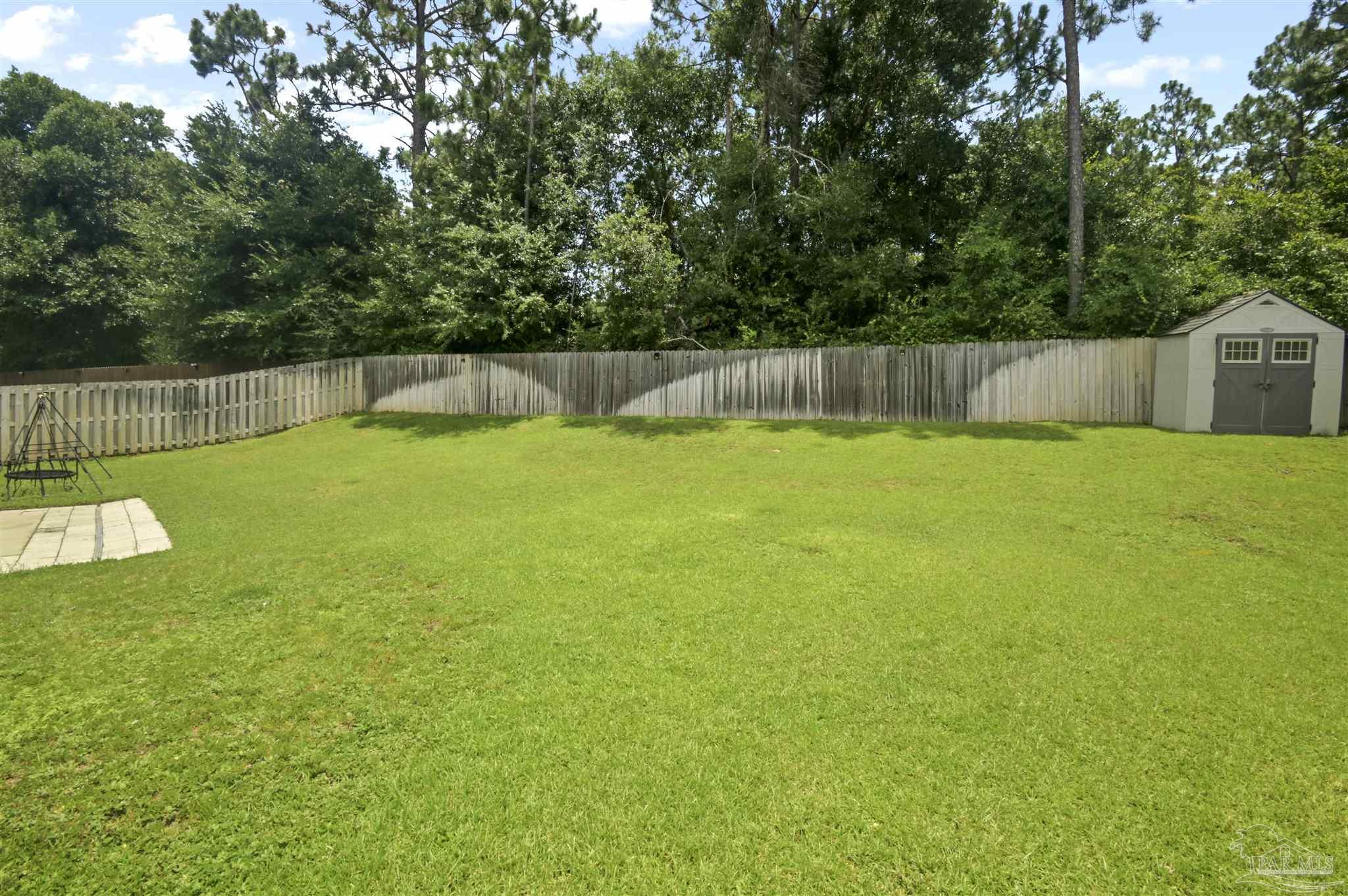 300 Cassady Lane Crestview, FL 32539 - Photo 23 of 25 a backyard of a house with trees and plants
