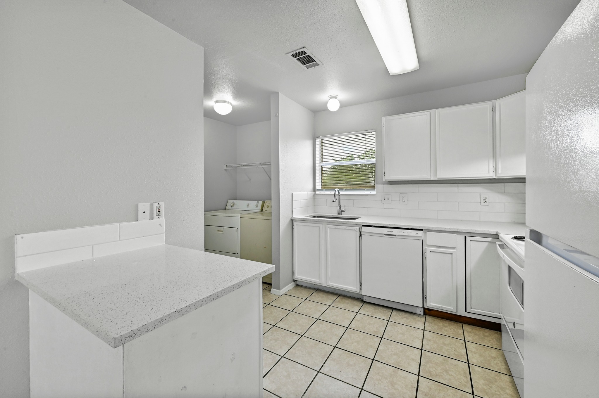 2212 Katy Lane Georgetown, TX 78626 - Photo 12 of 27 The kitchen features white cabinetry, a white subway tile backsplash, and a white refrigerator
