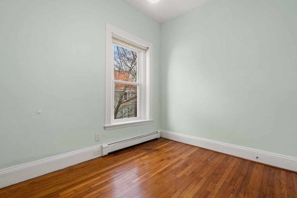 96 Brook Street, Unit 3 Brookline, MA 02445 - Photo 15 of 32 an empty room with wooden floor and windows