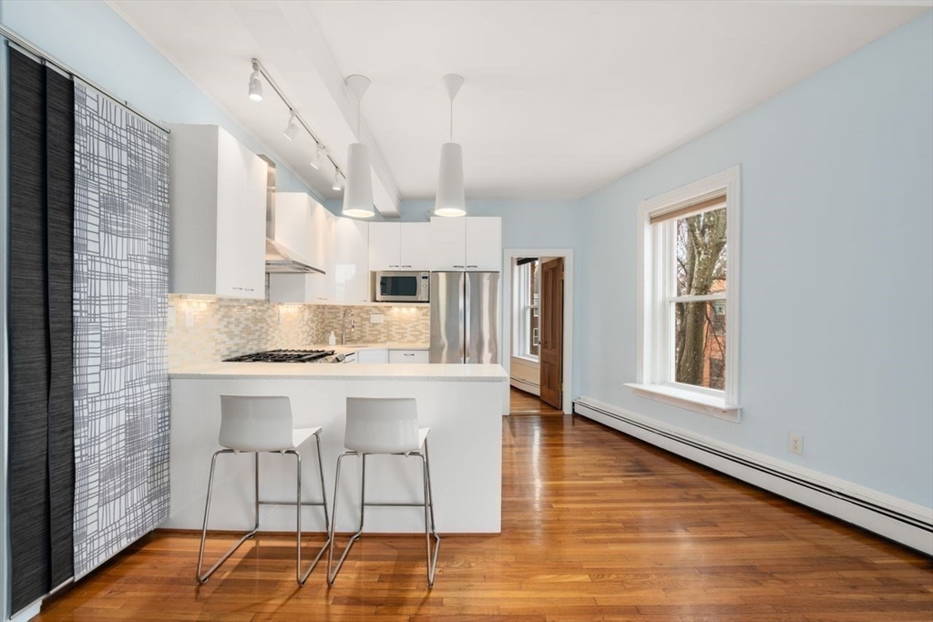 96 Brook Street, Unit 3 Brookline, MA 02445 - Photo 4 of 32 a kitchen with stainless steel appliances granite countertop a stove a sink dishwasher and a refrigerator with wooden floor