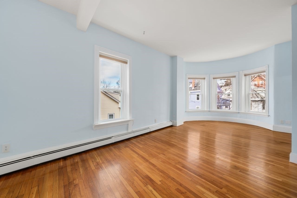 96 Brook Street, Unit 3 Brookline, MA 02445 - Photo 8 of 32 a view of an empty room with window and wooden floor