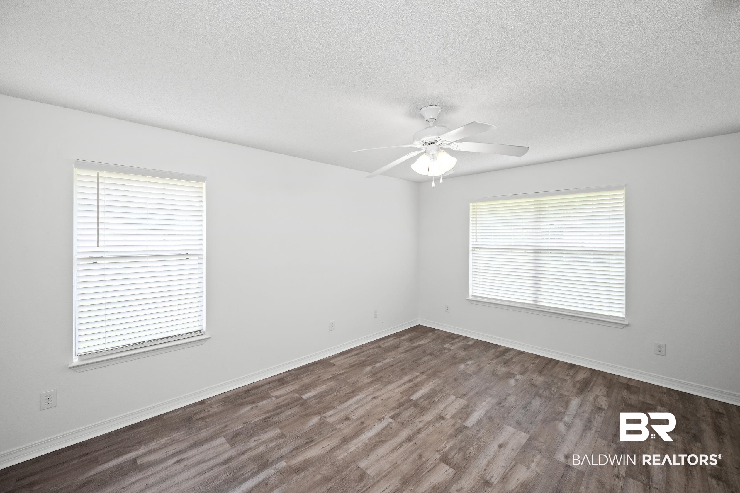 306 Monteith Oaks Drive Foley, AL 36535 - Photo 12 of 38 Empty room featuring dark wood finished floors, a textured ceiling, and ceiling fan