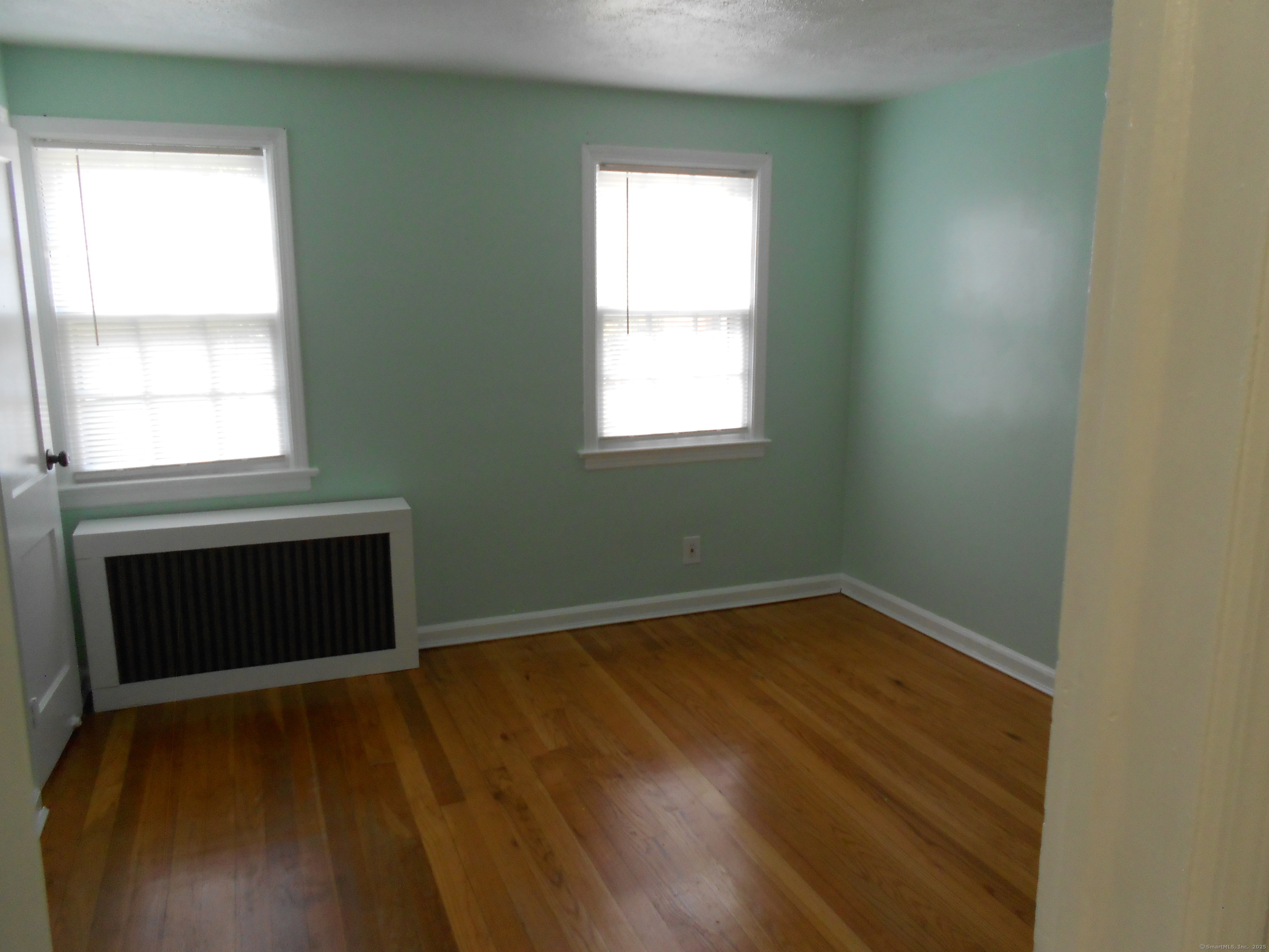 18 Bridge Street, Unit 1O Naugatuck, CT 06770 - Photo 4 of 11 a view of an empty room with wooden floor and a window