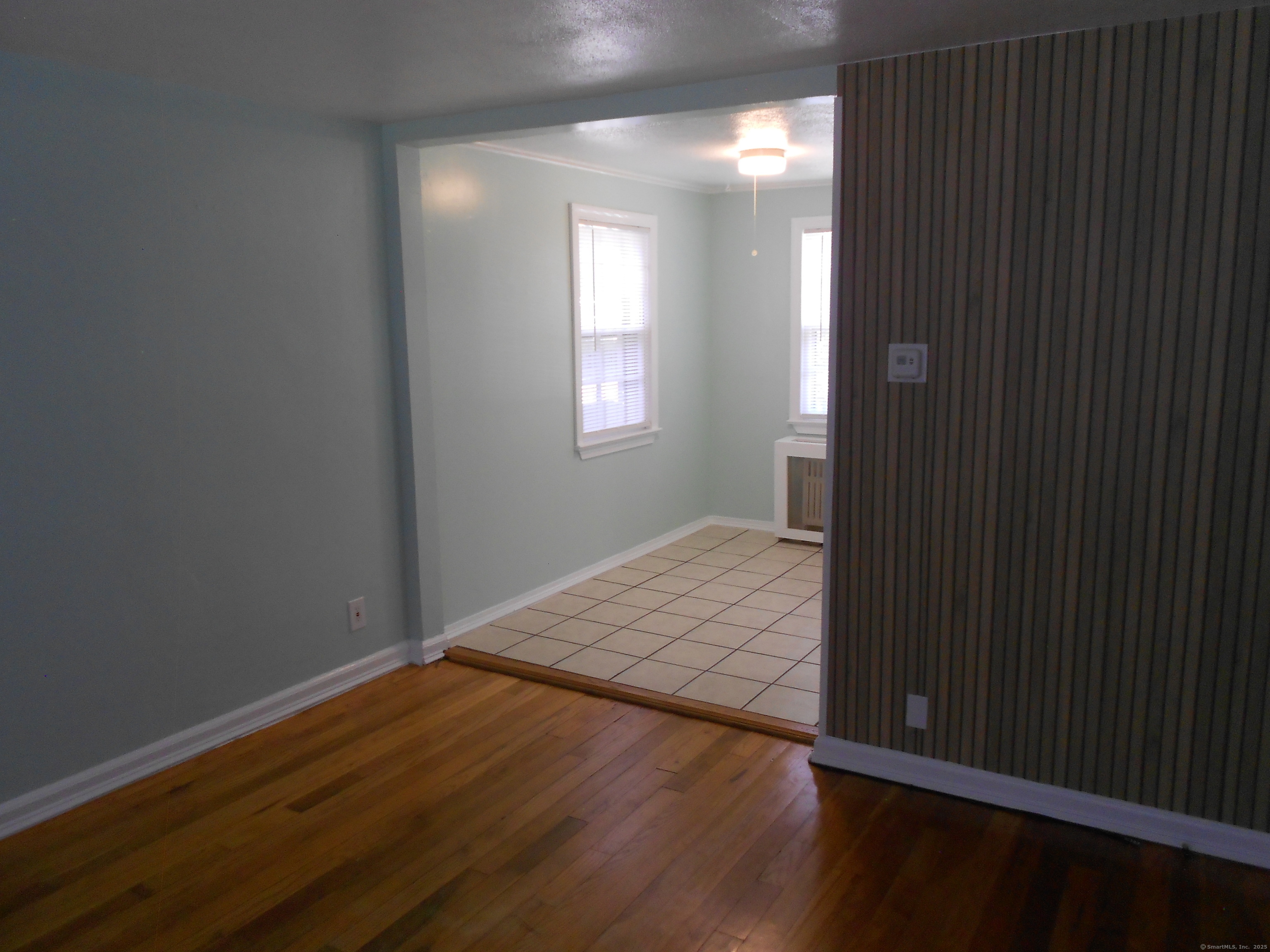 18 Bridge Street, Unit 1O Naugatuck, CT 06770 - Photo 9 of 11 a view of an empty room with wooden floor and a window