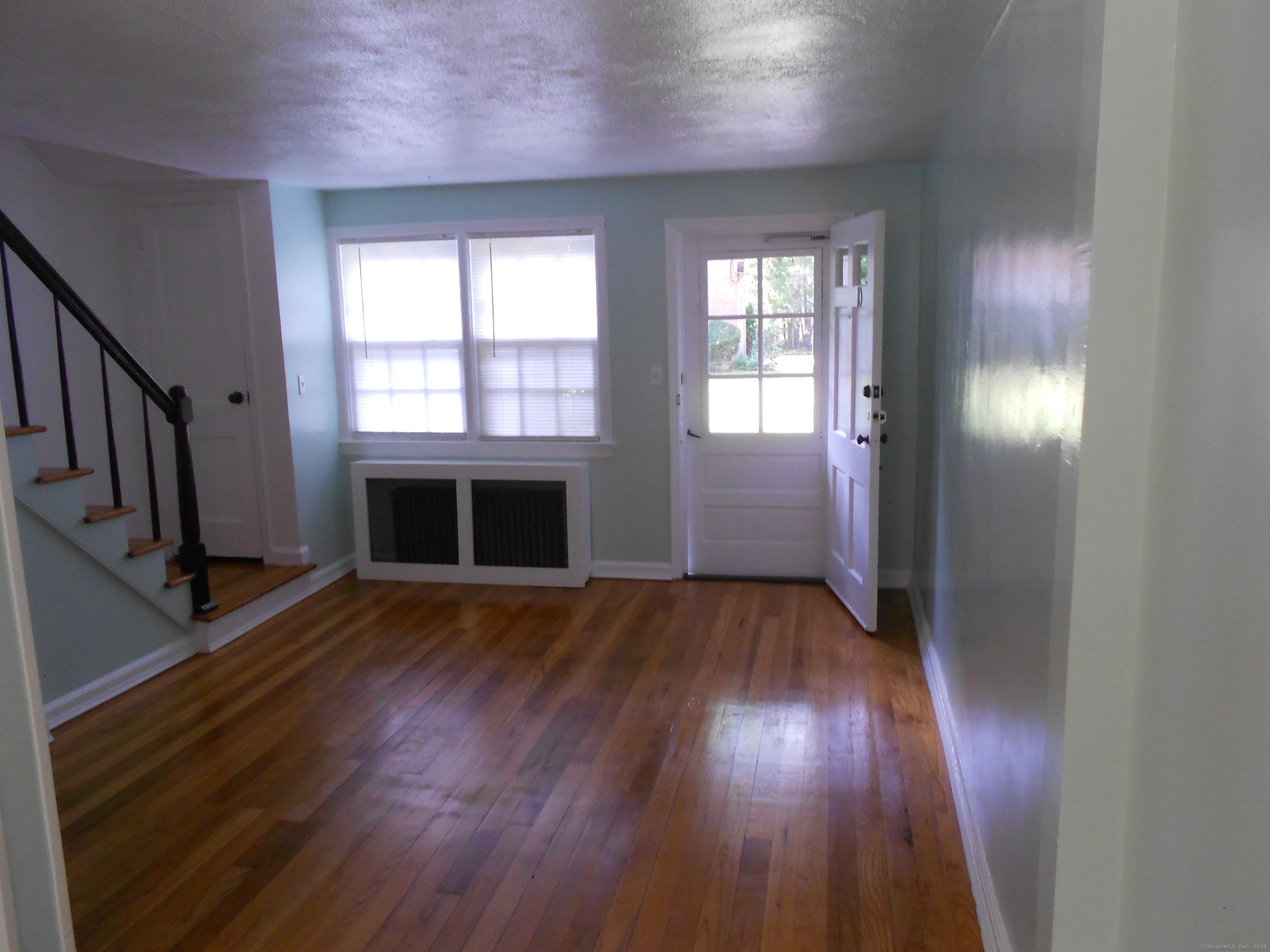 18 Bridge Street, Unit 1O Naugatuck, CT 06770 - Photo 10 of 11 an empty room with wooden floor and windows