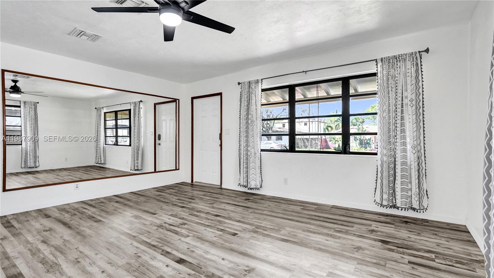1007 North 31st Road Hollywood, FL 33021 - Photo 13 of 54 a view of an empty room with a window and wooden floor
