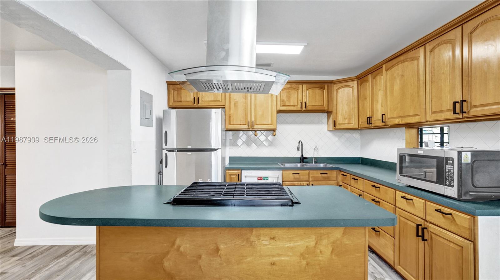 1007 North 31st Road Hollywood, FL 33021 - Photo 16 of 54 a kitchen with sink a refrigerator and cabinets