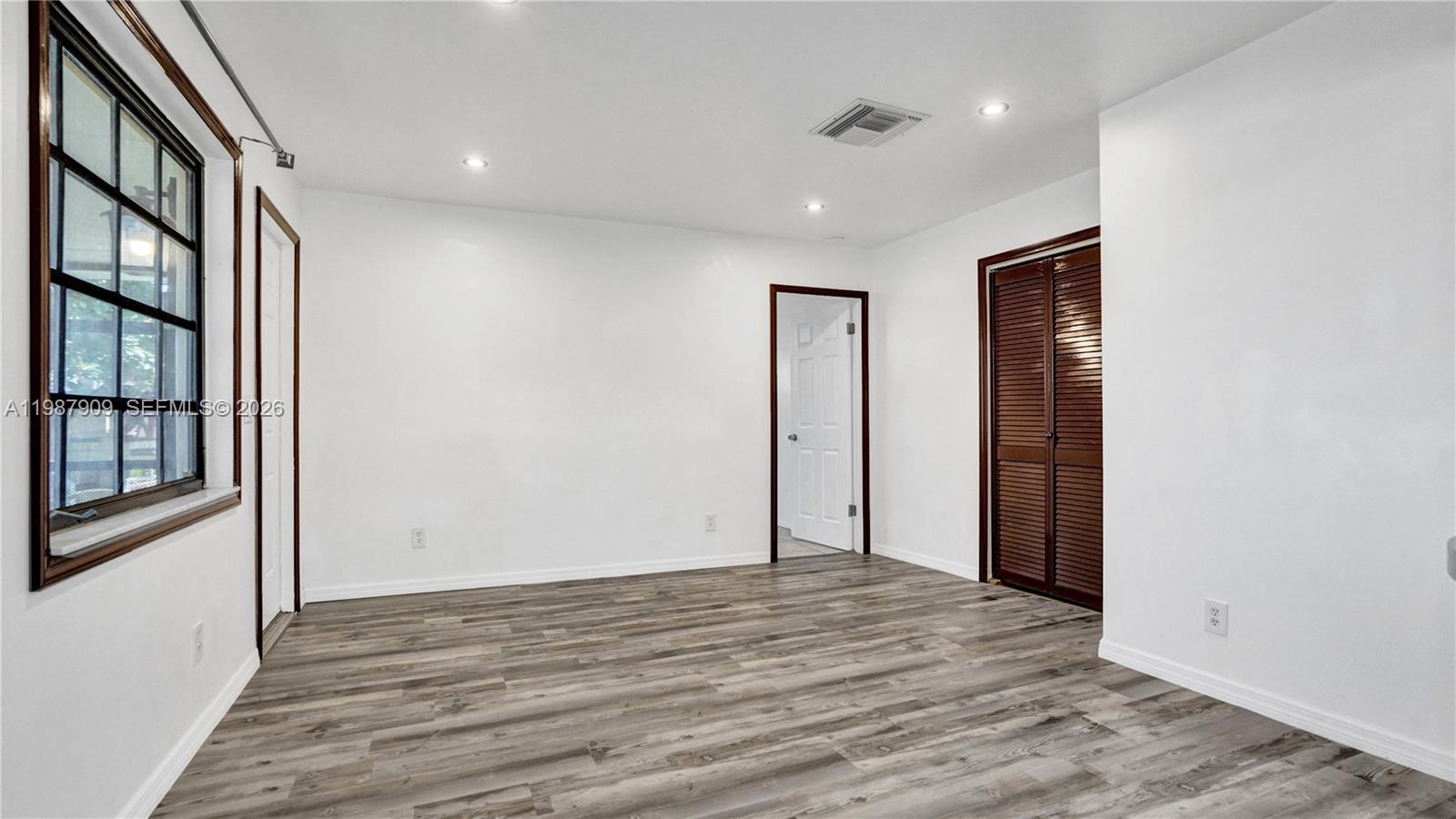 1007 North 31st Road Hollywood, FL 33021 - Photo 19 of 54 a view of an empty room with wooden floor and a window