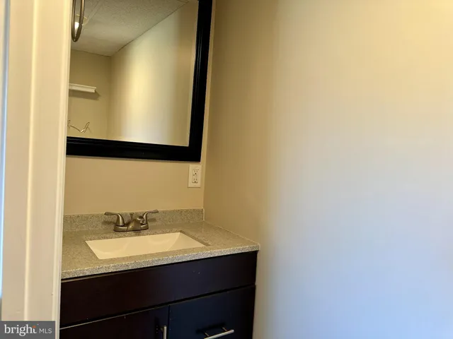 a view of a big room with wooden floor a ceiling fan and windows