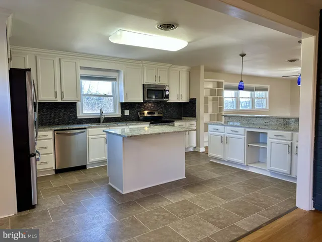 a kitchen with granite countertop a sink a counter and cabinets