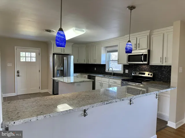 a view of a kitchen with a sink and a chandelier