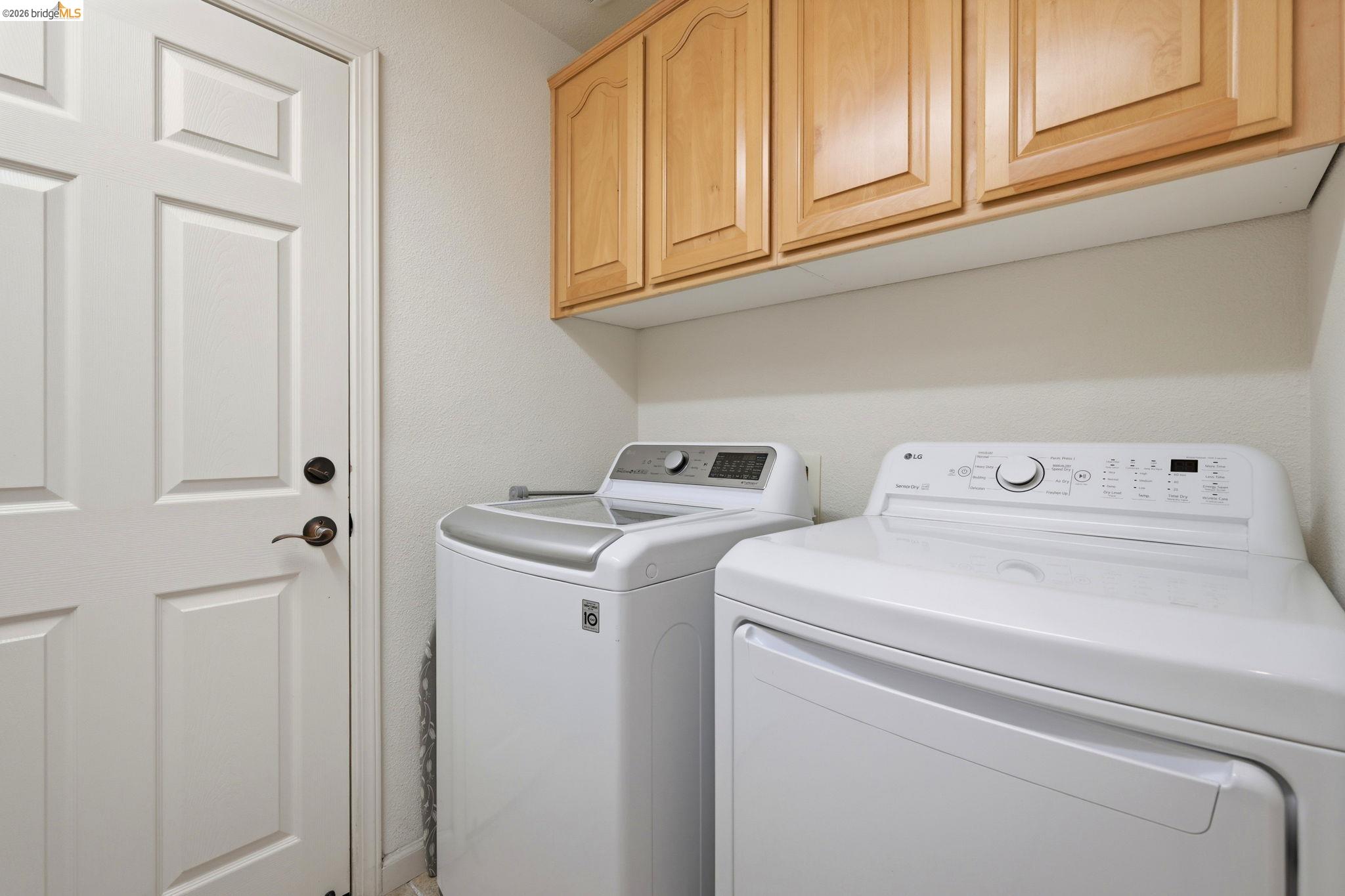 1024 Diamante Rio Vista, CA 94571 - Photo 21 of 27 Laundry area featuring overhead wood cabinetry, white paneled door, and neutral wall finishes
