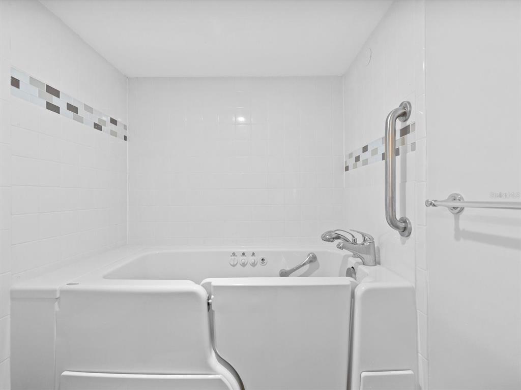 2737 Enterprise Road East, Unit 111 Clearwater, FL 33759 - Photo 11 of 28 a white bath tub sitting next to a white sink