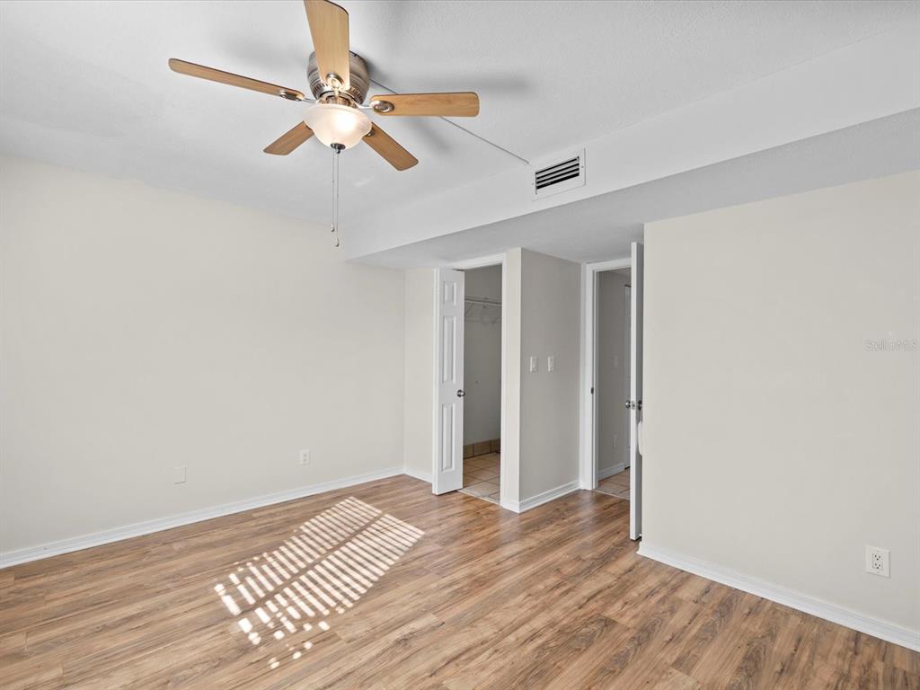 2737 Enterprise Road East, Unit 111 Clearwater, FL 33759 - Photo 13 of 28 a view of a room with wooden floor and ceiling fan