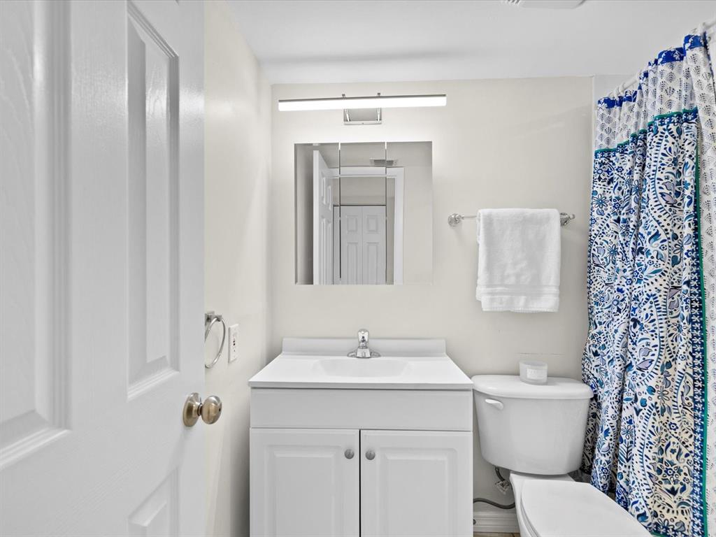 2737 Enterprise Road East, Unit 111 Clearwater, FL 33759 - Photo 15 of 28 a bathroom with a toilet sink and mirror