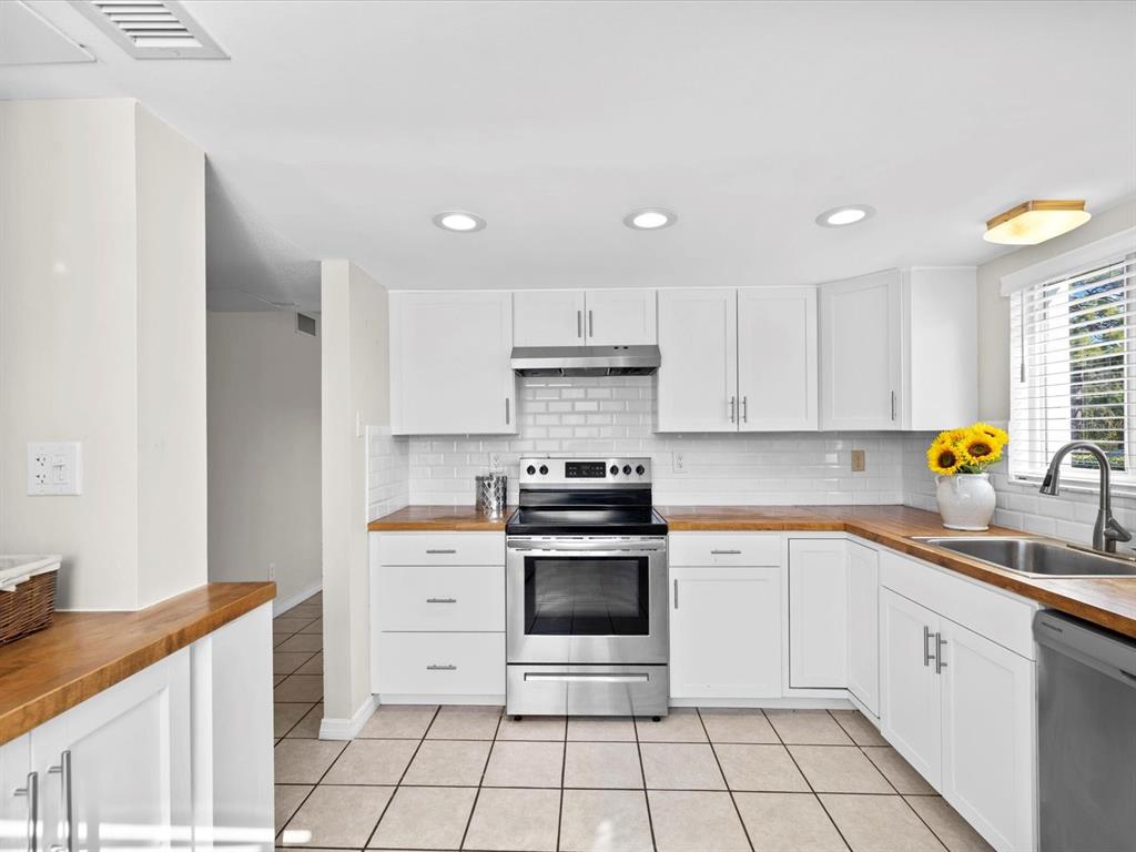2737 Enterprise Road East, Unit 111 Clearwater, FL 33759 - Photo 21 of 28 a kitchen with a stove sink and cabinets