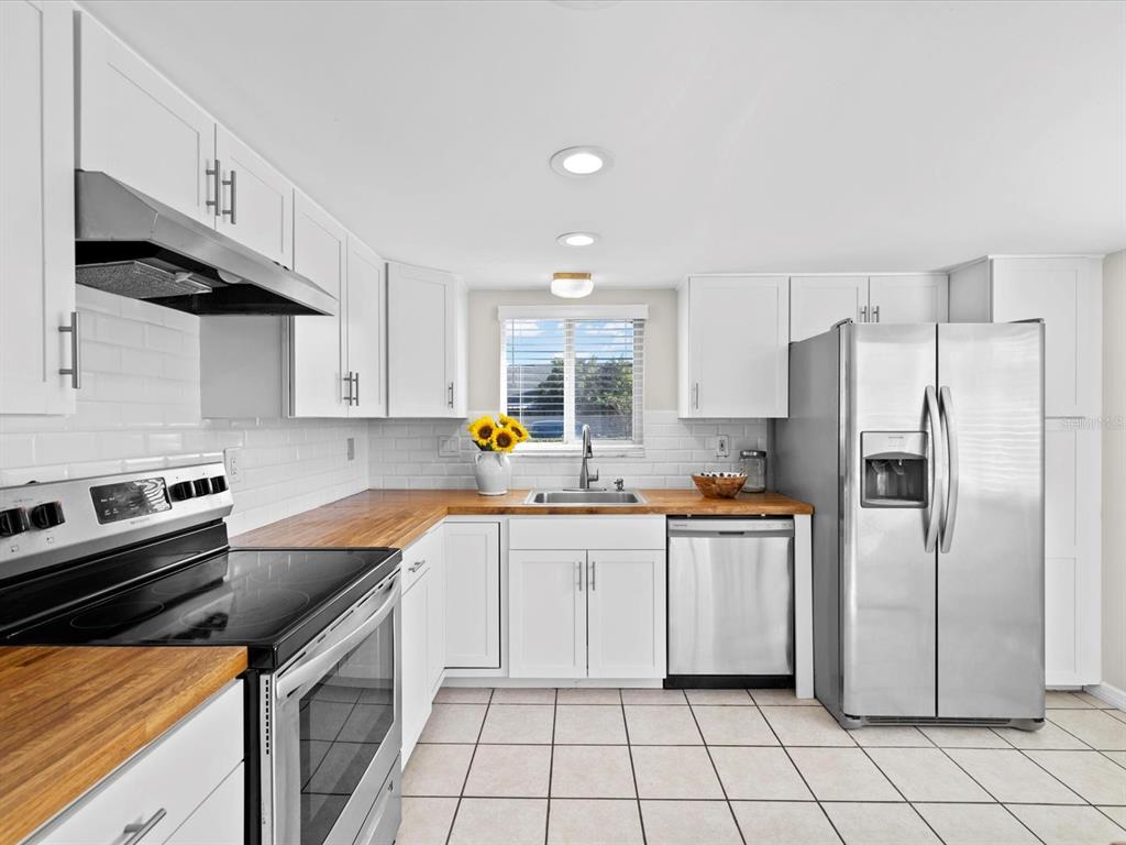 2737 Enterprise Road East, Unit 111 Clearwater, FL 33759 - Photo 6 of 28 a kitchen with granite countertop a sink stove and refrigerator
