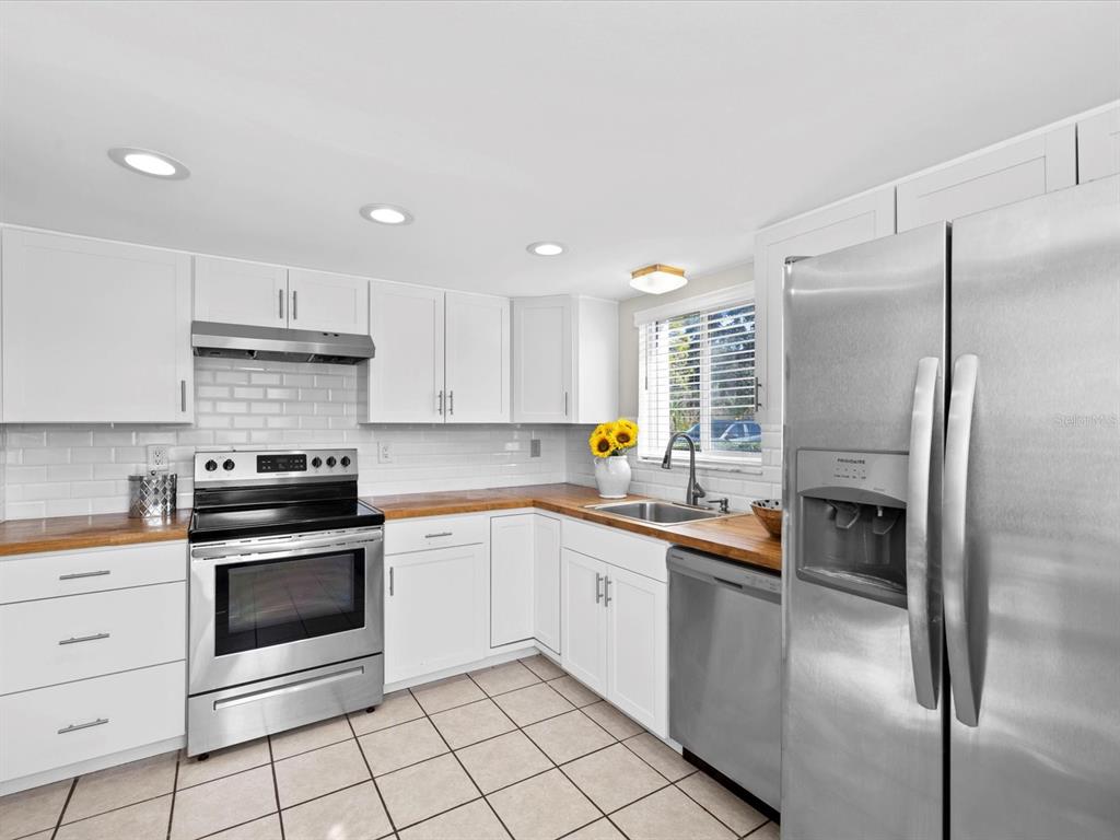 2737 Enterprise Road East, Unit 111 Clearwater, FL 33759 - Photo 7 of 28 a kitchen with stainless steel appliances granite countertop a refrigerator sink and stove