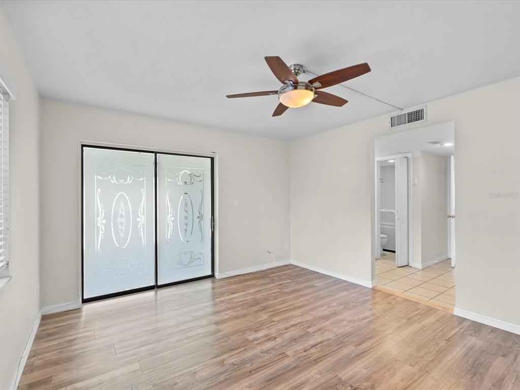 2737 Enterprise Road East, Unit 111 Clearwater, FL 33759 - Photo 9 of 28 a view of empty room with wooden floor and fan