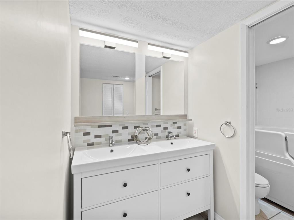2737 Enterprise Road East, Unit 111 Clearwater, FL 33759 - Photo 10 of 28 a bathroom with a sink vanity mirror and toilet