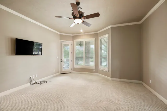 a view of an empty room with a window and a flat screen tv
