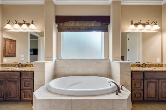 a bathroom with a tub sink and mirror